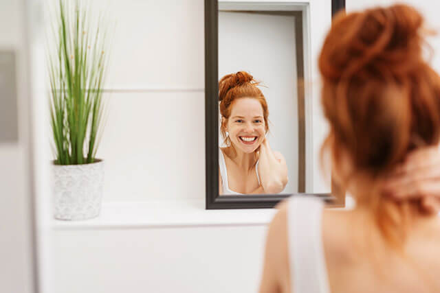 Young woman smiling in the mirror