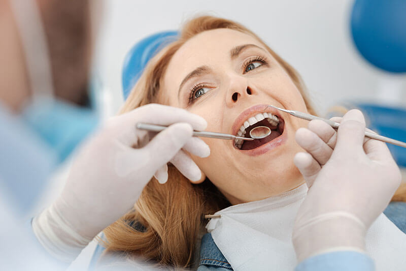 Middle-aged woman getting her teeth examined